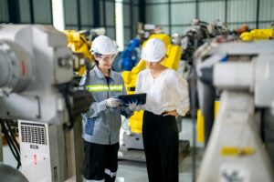 Engineer inspecting automatic AI robot arm and machines in factory. Engineer inspecting automatic AI